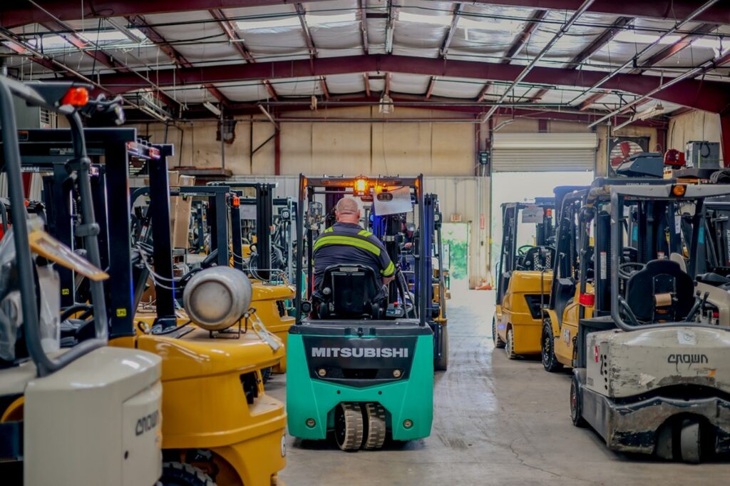 Forklift Moving Through Warehouse with Multiple Lift Trucks Parked